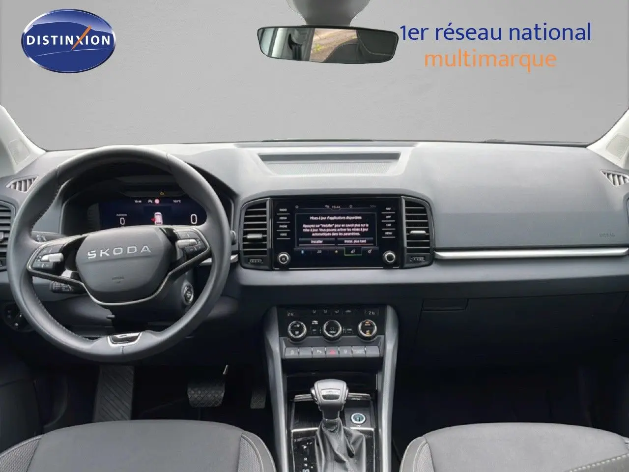 Intérieur noir du Skoda Karoq 2025, vue frontale du tableau de bord avec volant multifonction et écran central tactile.