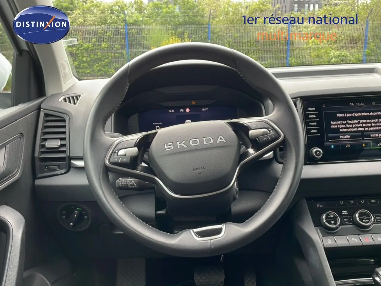 Vue intérieure centrée sur le volant noir du Skoda Karoq 2025 avec tableau de bord et écran tactile visibles.