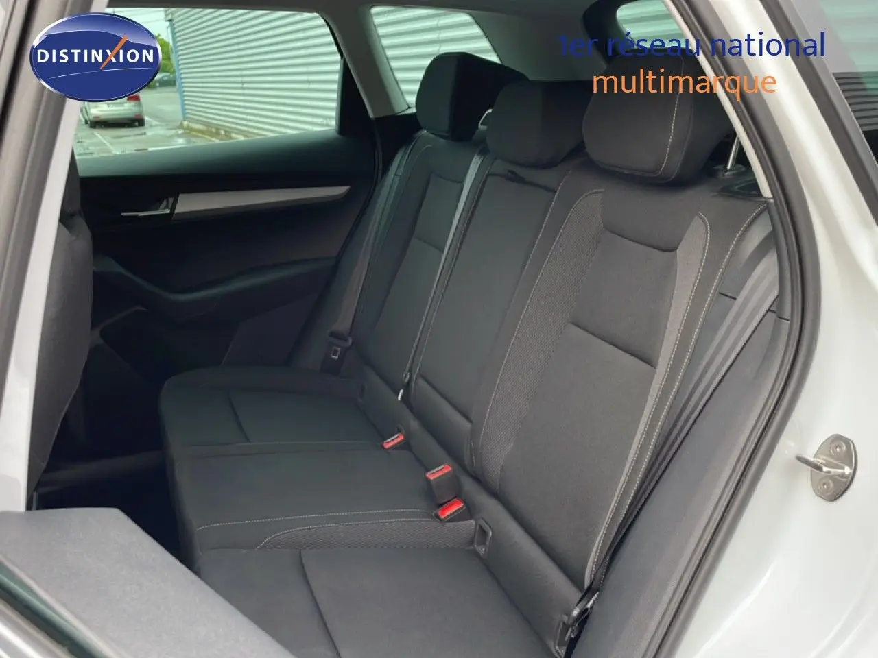 Vue intérieure côté gauche montrant la banquette arrière noire du Skoda Karoq blanc glacier 2025, finition Selection.