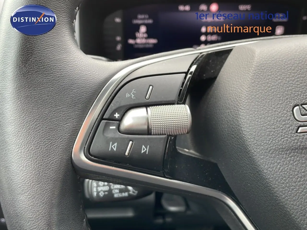 Vue rapprochée du volant multifonction noir du Skoda Karoq blanc glacier, mettant en valeur les commandes audio et vocales.