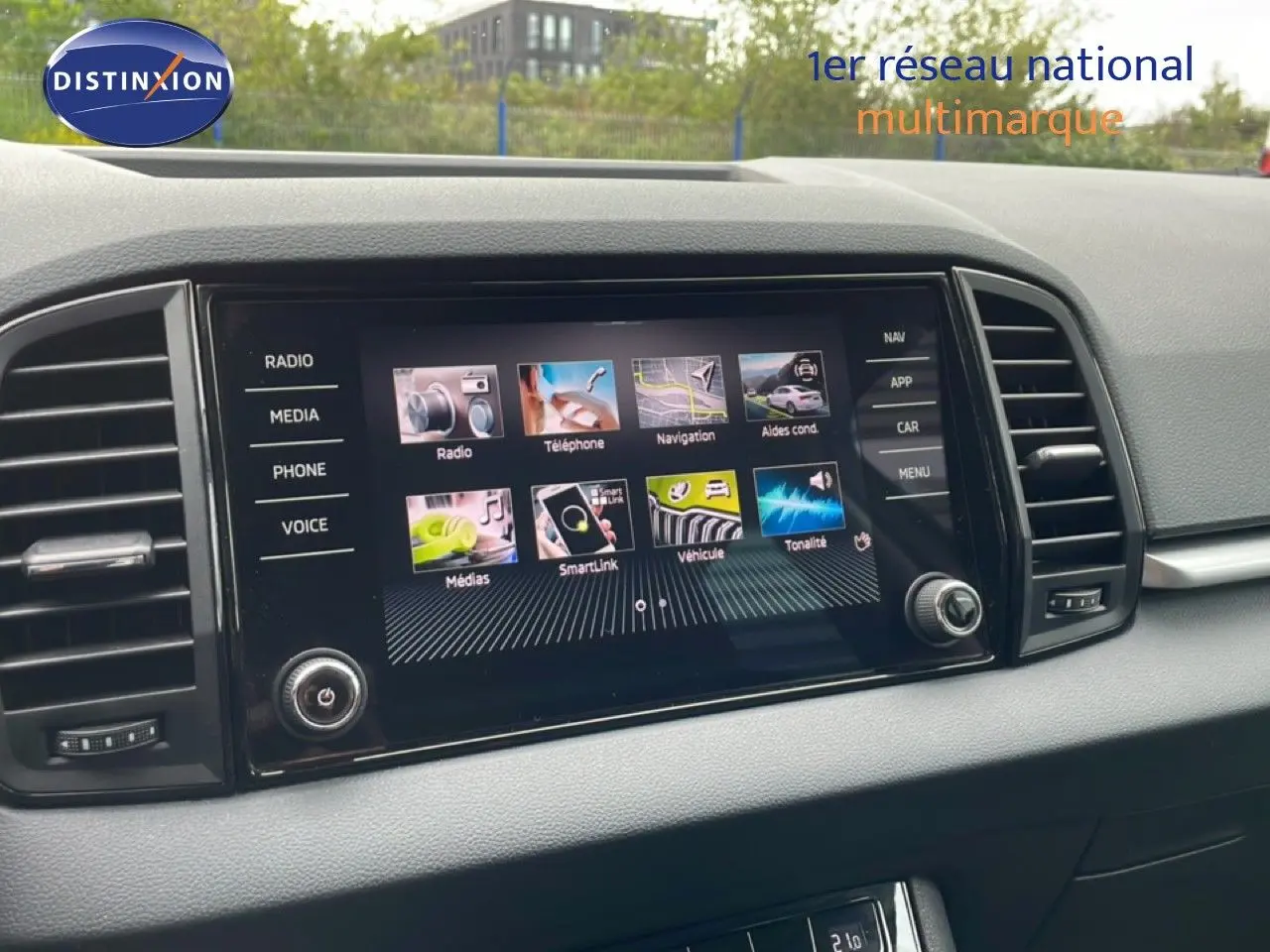 Écran tactile central du tableau de bord du Skoda Karoq blanc glacier, vue de face en intérieur.