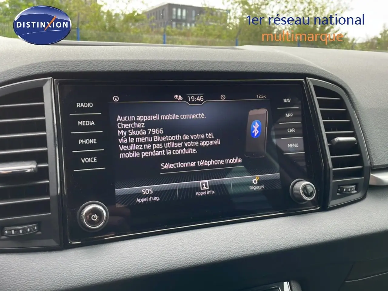 Écran central tactile du tableau de bord du Skoda Karoq blanc glacier, affichant le menu Bluetooth et les options multimédia.