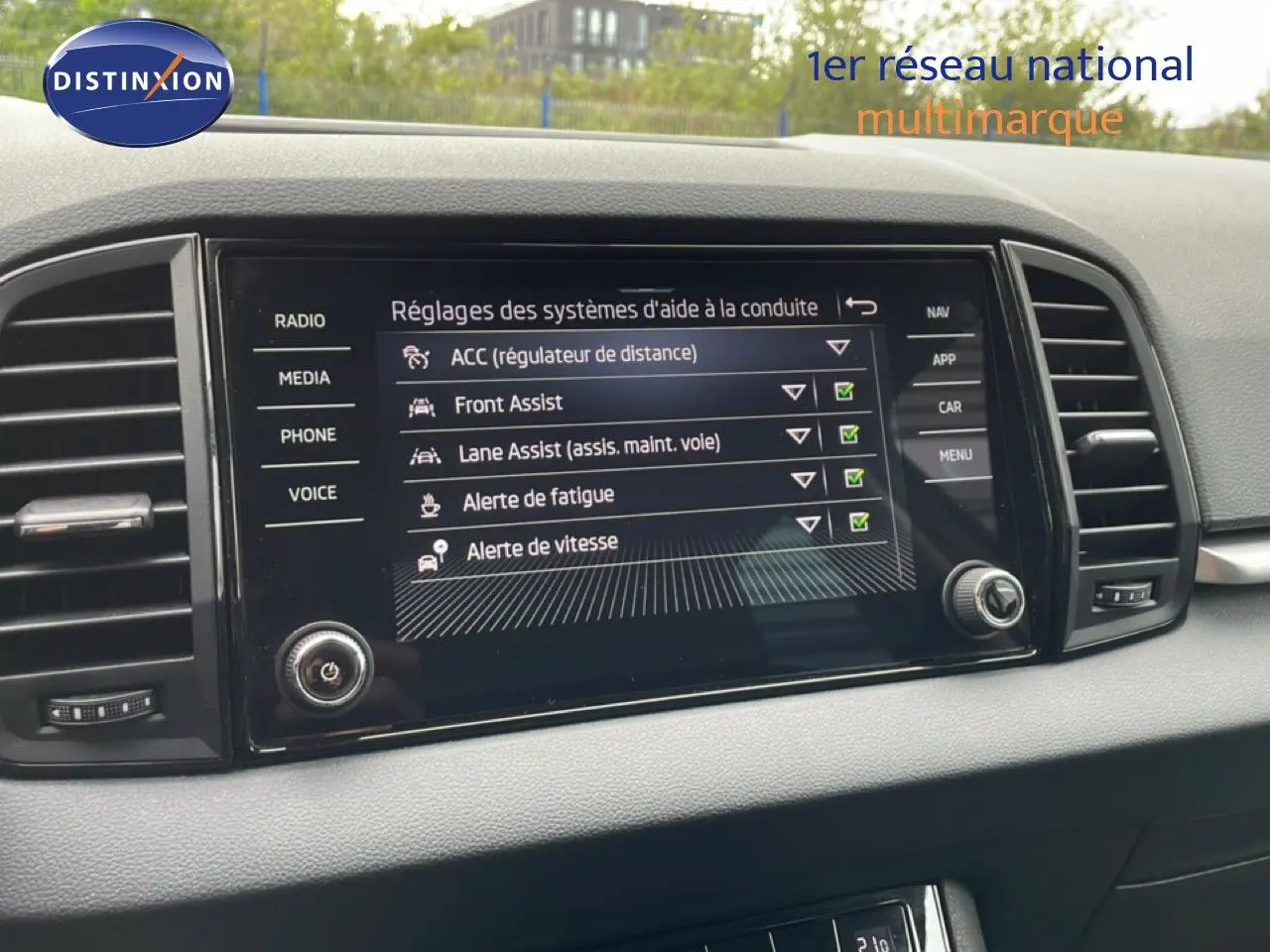Écran central tactile du Skoda Karoq blanc glacier 2025 affichant les réglages des aides à la conduite.