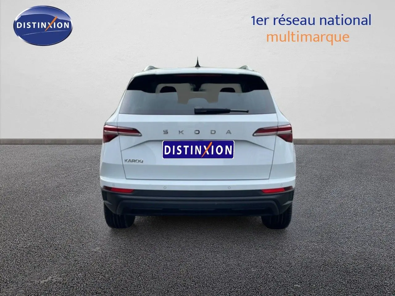 Vue arrière d'un Skoda Karoq blanc glacier 2025 avec feux arrière LED et logo SKODA visible.