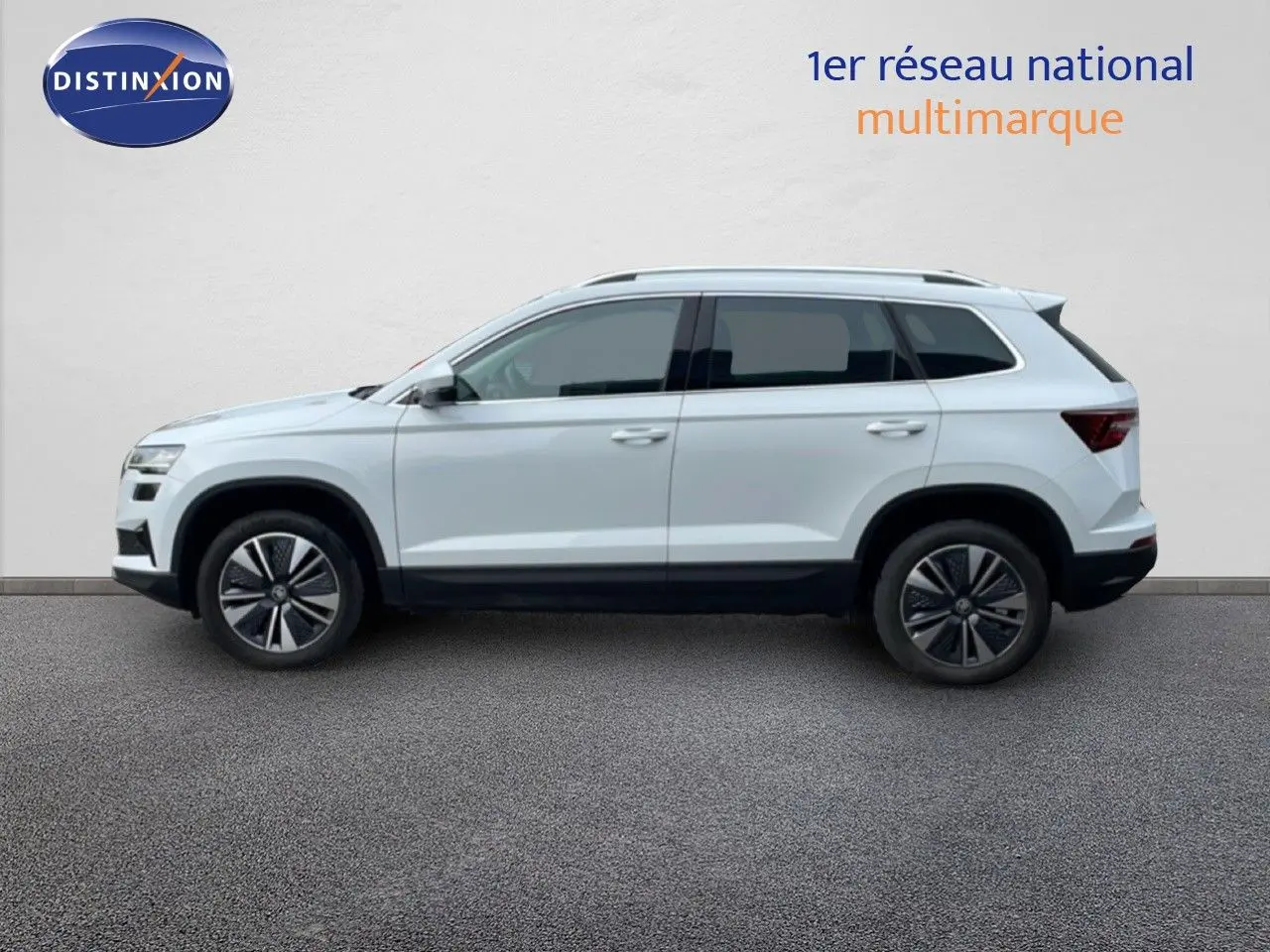 Profil droit d’un Skoda Karoq blanc glacier 2025, SUV compact avec jantes alliage et vitres teintées.