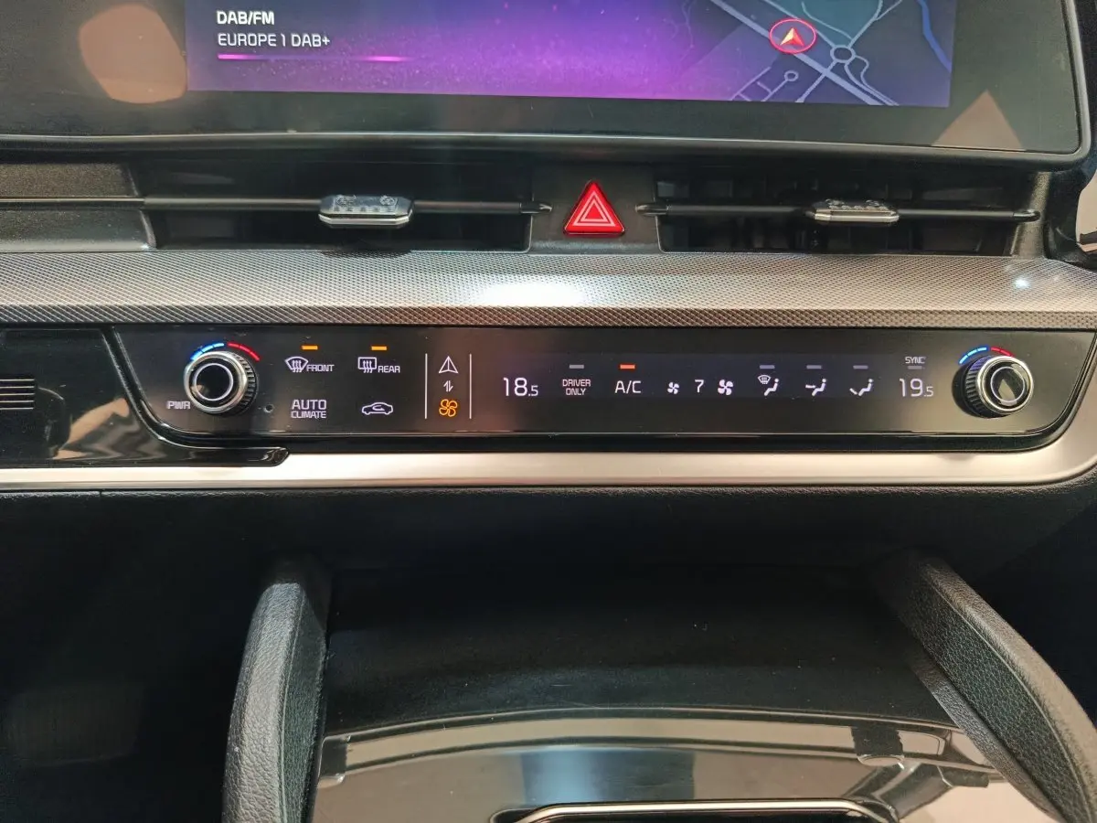 Gros plan sur la console centrale du Kia Sportage blanc 2022, affichage digital de la climatisation et commandes tactiles.