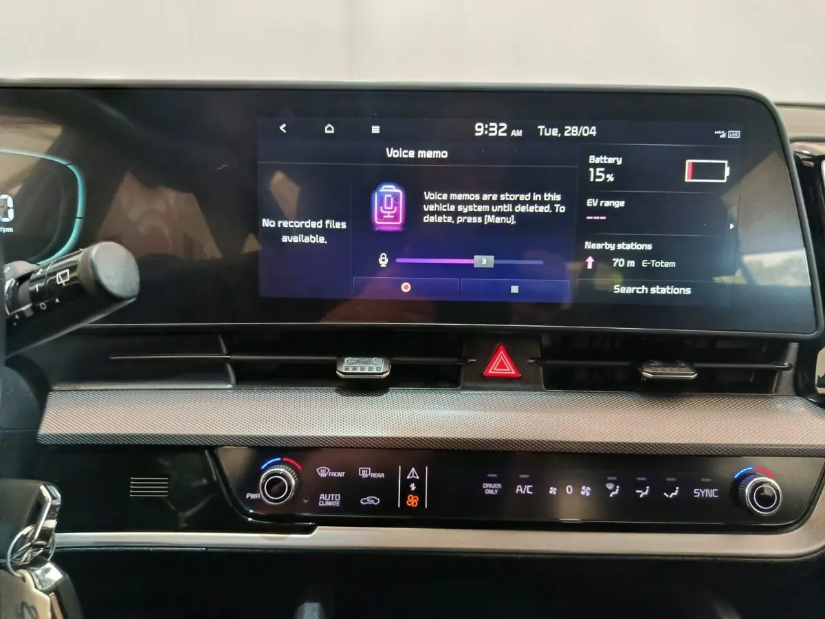 Tableau de bord du Kia Sportage hybride rechargeable 2022 avec écran tactile central et commandes climatisation digitales.