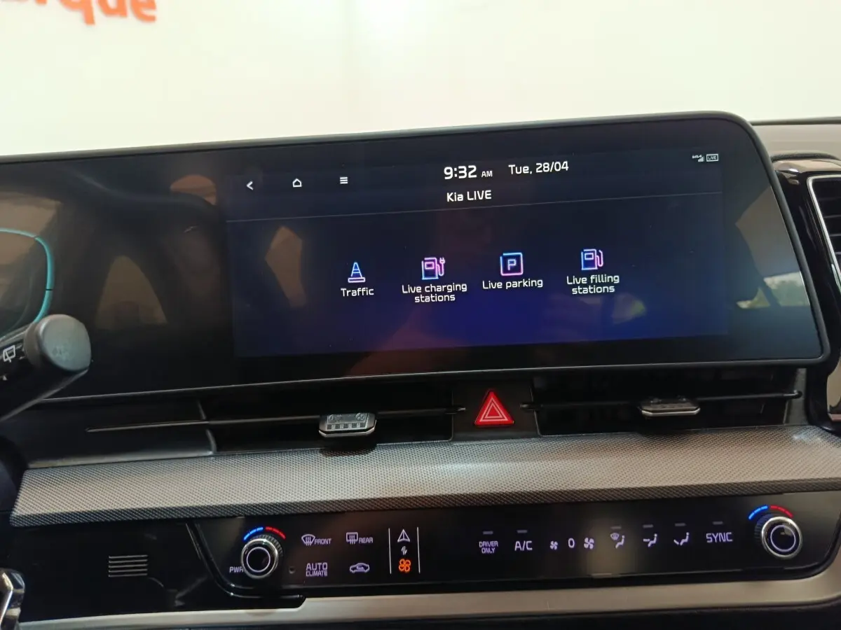 Vue rapprochée du tableau de bord numérique du Kia Sportage 2022 avec écran tactile affichant options de navigation et climatisation.