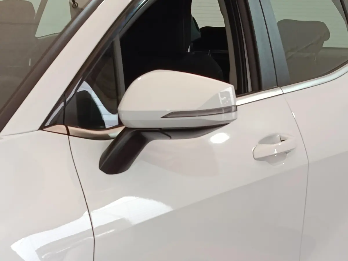 Gros plan sur le rétroviseur côté gauche blanc du Kia Sportage 2022 hybride rechargeable avec portière ouverte.