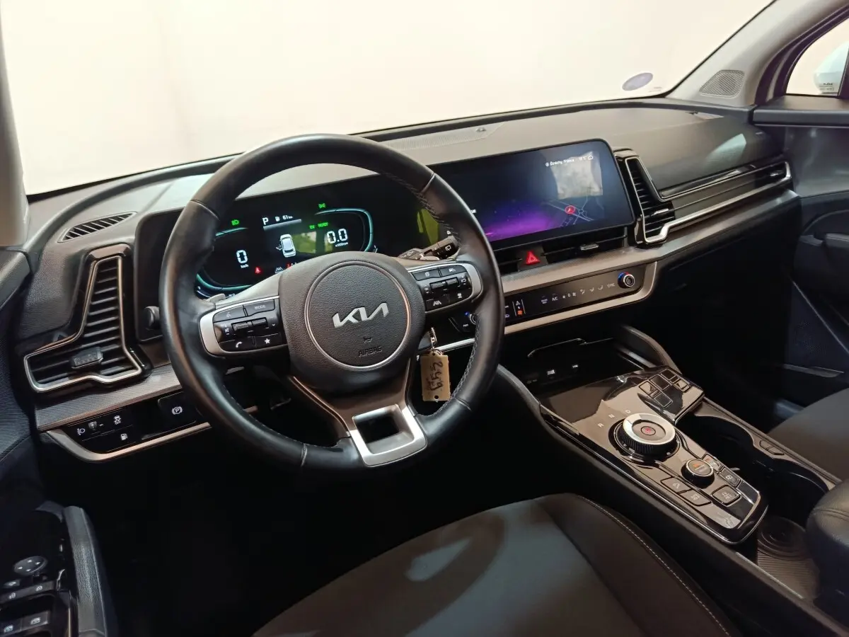 Vue intérieure côté conducteur du tableau de bord et volant cuir noir du Kia Sportage hybride rechargeable 2022.