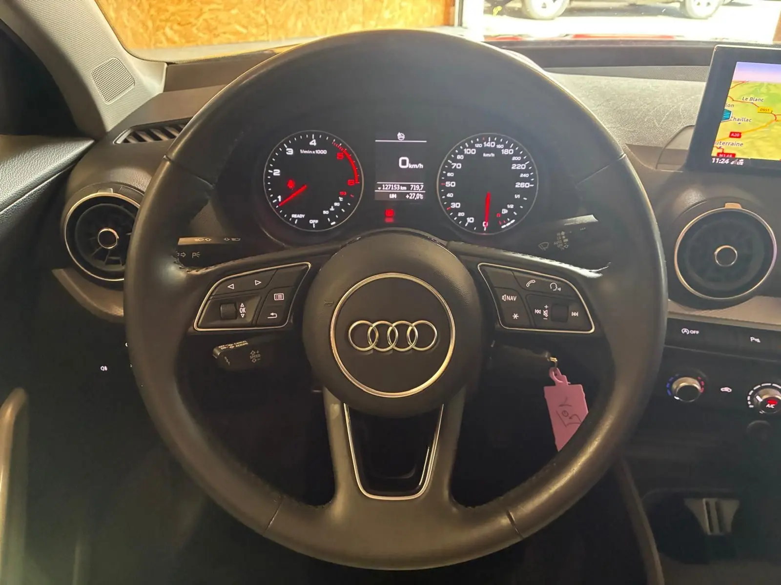 Vue centrée sur le volant noir d'Audi Q2 2020 avec tableau de bord digital et écran GPS visible à droite.