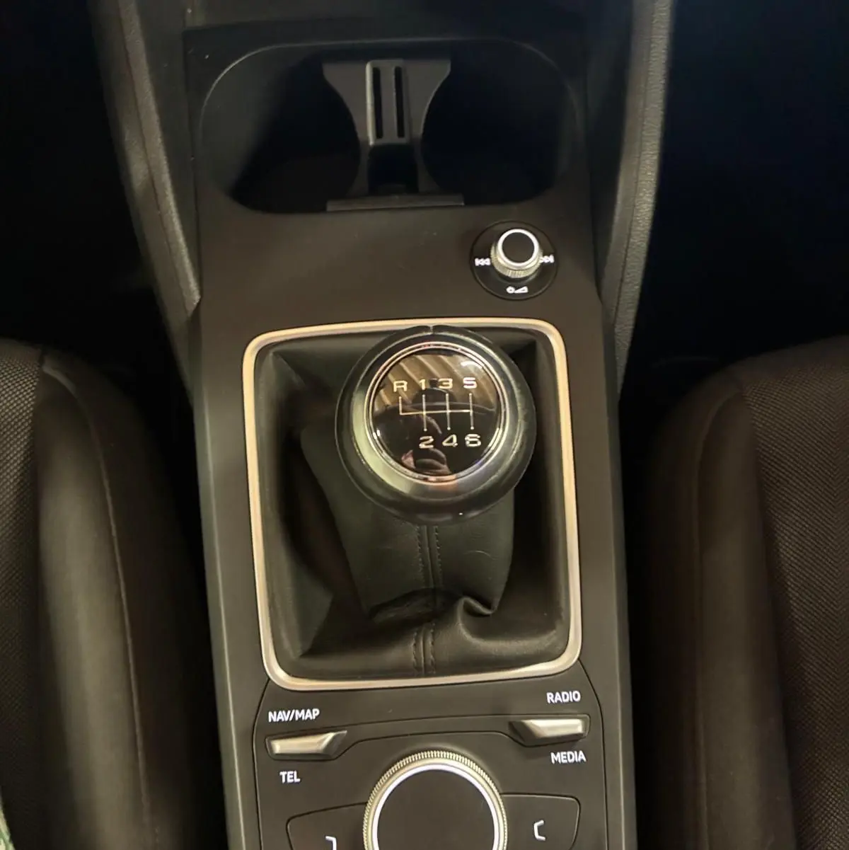 Vue rapprochée de la console centrale noire d’un Audi Q2 2020, mettant en valeur le levier de vitesse manuel et les commandes multimédia.