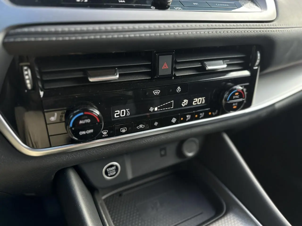 Vue rapprochée de la console centrale du Nissan Qashqai 2025, affichant la climatisation automatique bi-zone et le bouton Start/Stop.