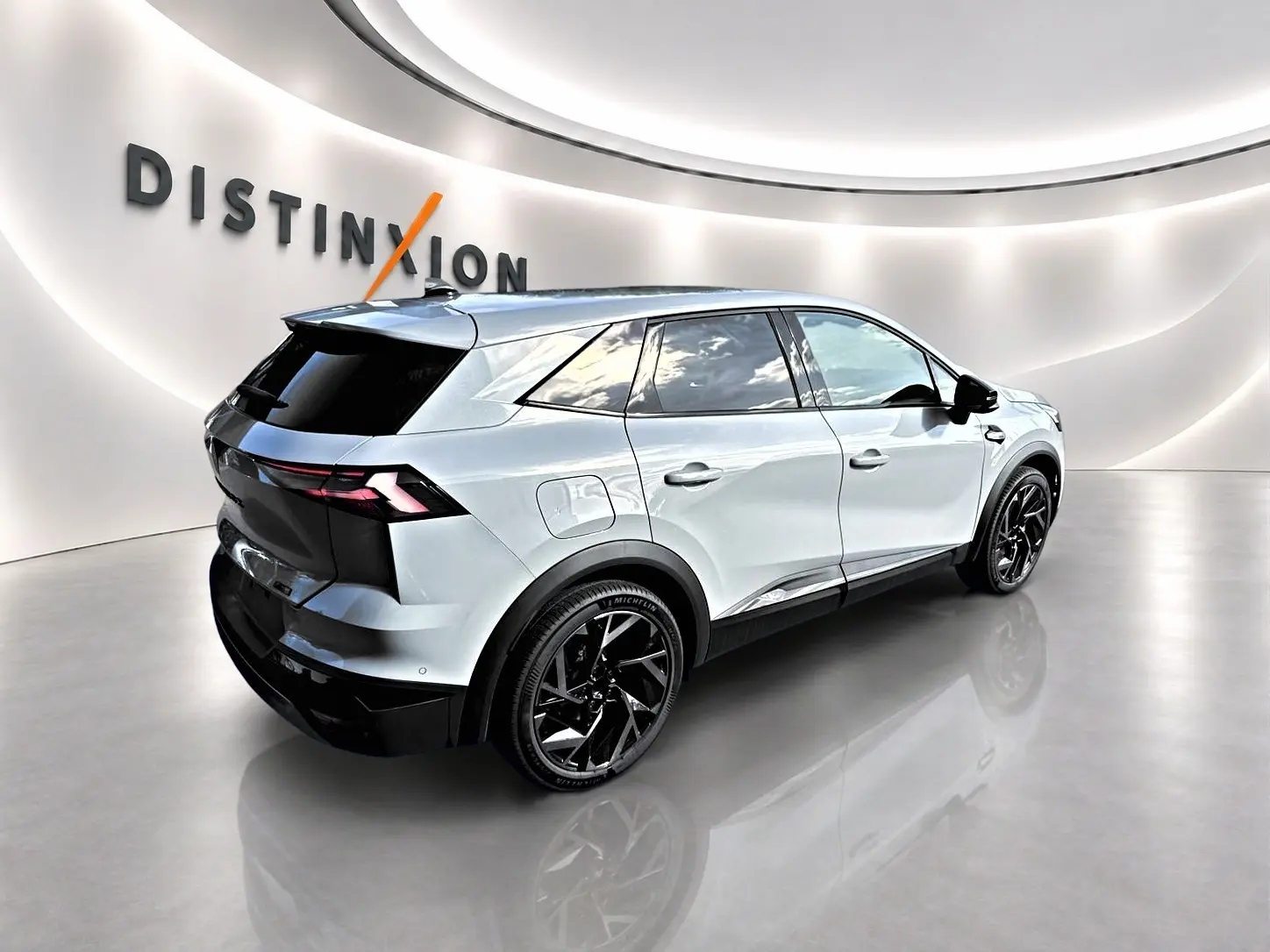 Vue 3/4 arrière droite du Renault SYMBIOZ gris rafale avec jantes noires et vitres surteintées dans un showroom.