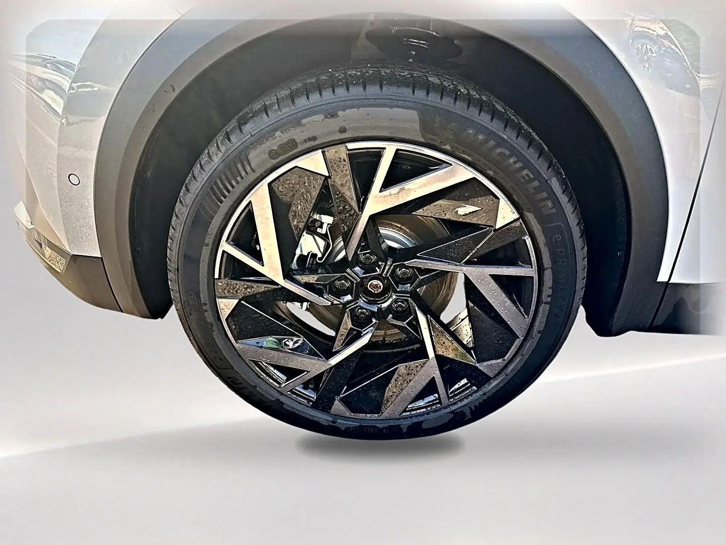 Gros plan sur la roue avant gauche du Renault Symbioz gris rafale, jante alu au design géométrique noir et argent.