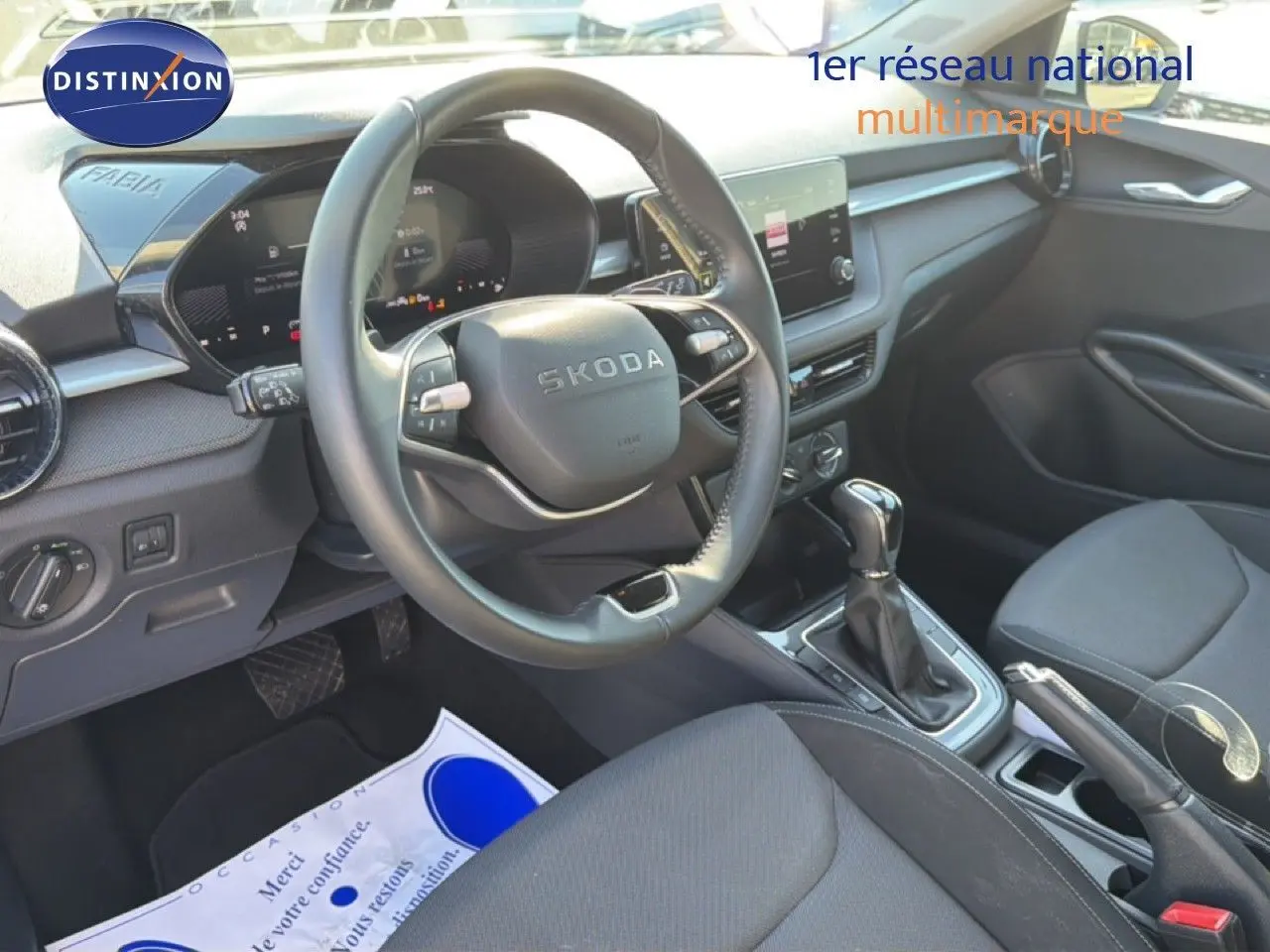 Vue intérieure côté conducteur de la Skoda Fabia 2025, volant cuir multifonction et console centrale avec boîte automatique.