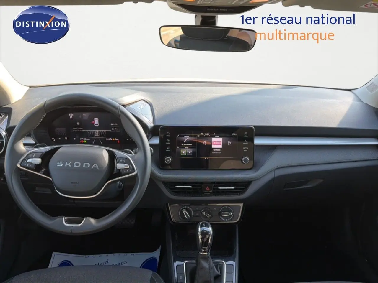 Vue intérieure avant du tableau de bord gris graphite d'une Skoda Fabia 2025 avec volant multifonction et écran tactile central.