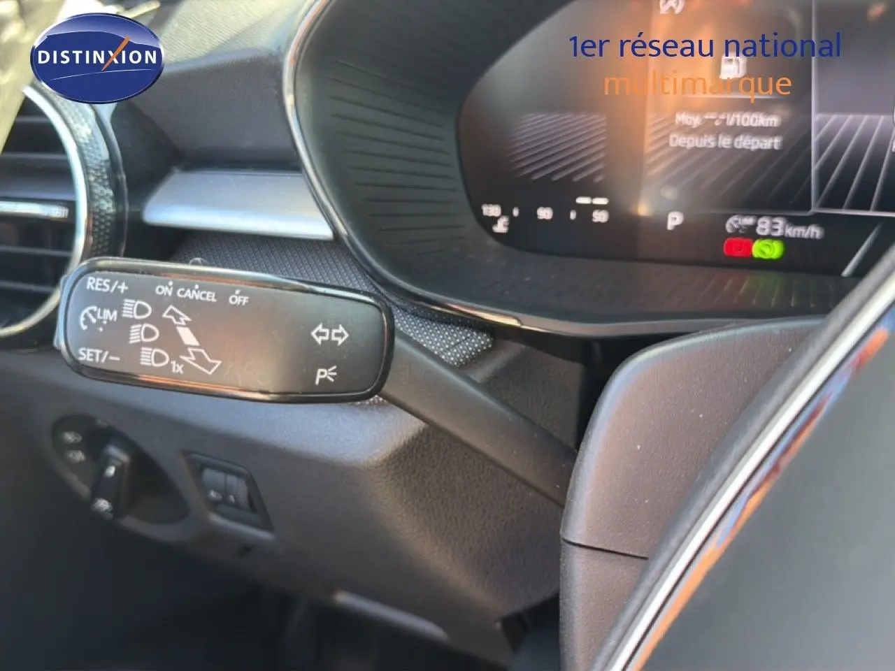 Gros plan sur la manette de régulateur de vitesse à gauche du volant dans l'habitacle gris foncé d'une Skoda Fabia 2025.