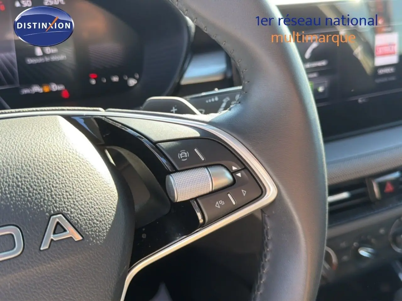 Gros plan sur le volant en cuir noir de la Skoda Fabia 2025, montrant les commandes multifonctions et partie du tableau de bord.