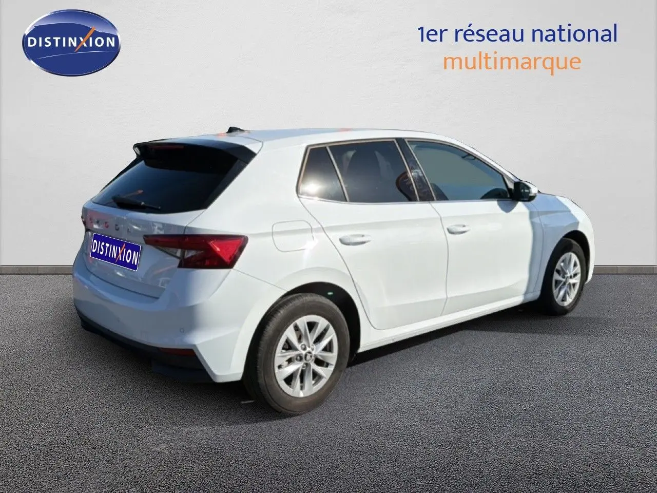 Vue 3/4 arrière droite d'une Skoda Fabia blanche, avec vitres teintées et jantes alliage.