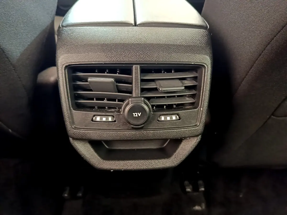 Gros plan sur la prise 12V et les bouches d’aération arrière du Peugeot 3008 bleu, intérieur noir.