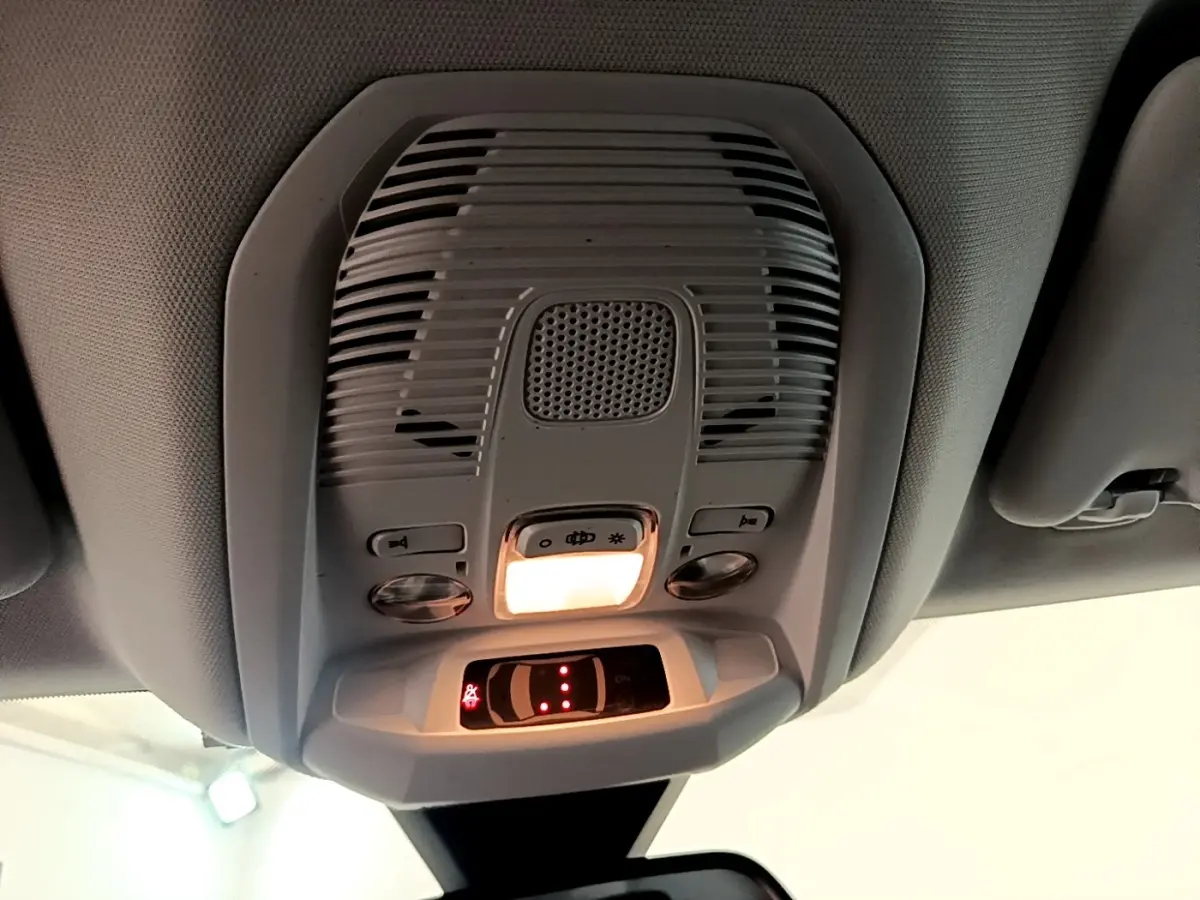 Vue en contre-plongée du plafonnier gris avec éclairage intérieur allumé du Peugeot 3008 bleu 2022.