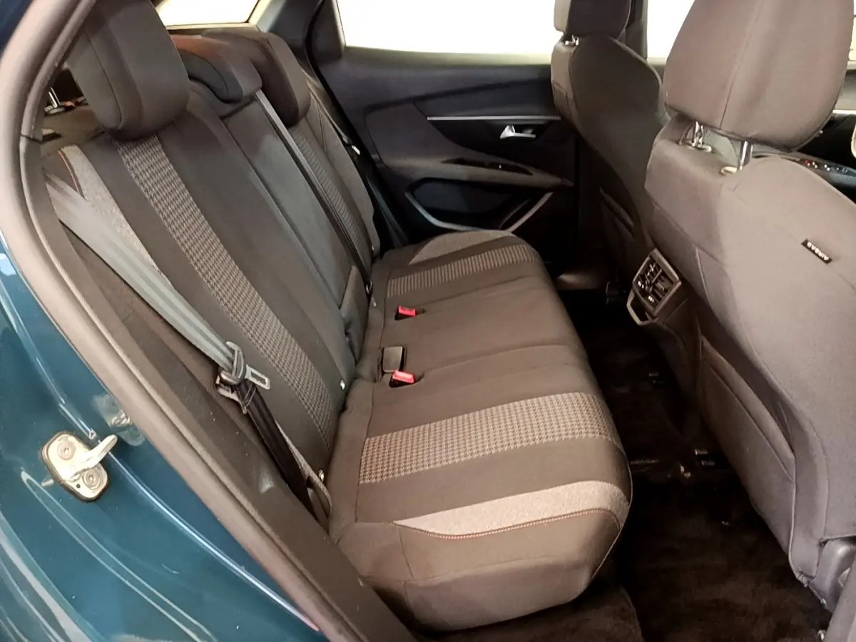 Vue intérieure côté gauche des sièges arrière tissu gris du Peugeot 3008 bleu, montrant l'ouverture de porte et ceintures.