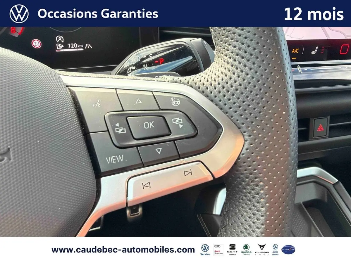 Gros plan sur le volant multifonction perforé noir du Volkswagen T-Roc 2026 avec commandes intégrées et tableau de bord numérique.