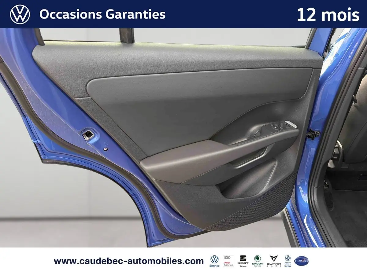 Vue rapprochée de la porte arrière gauche d’un Volkswagen T-Roc bleu métallisé avec garniture intérieure grise.