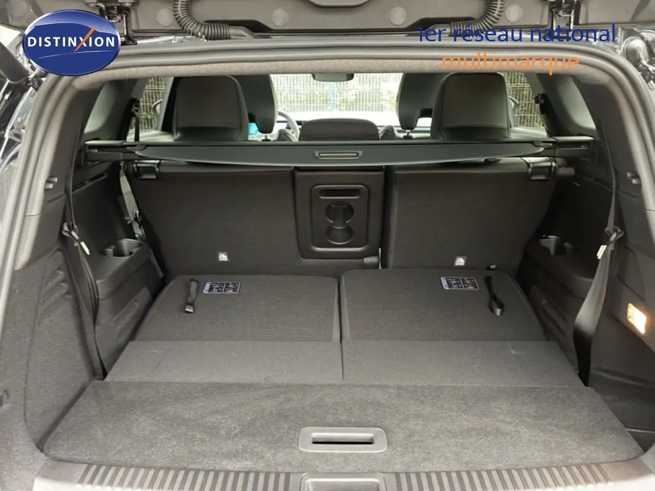 Coffre ouvert du Renault Espace noir étoile métal 2025, sièges arrière rabattus et intérieur spacieux visible.