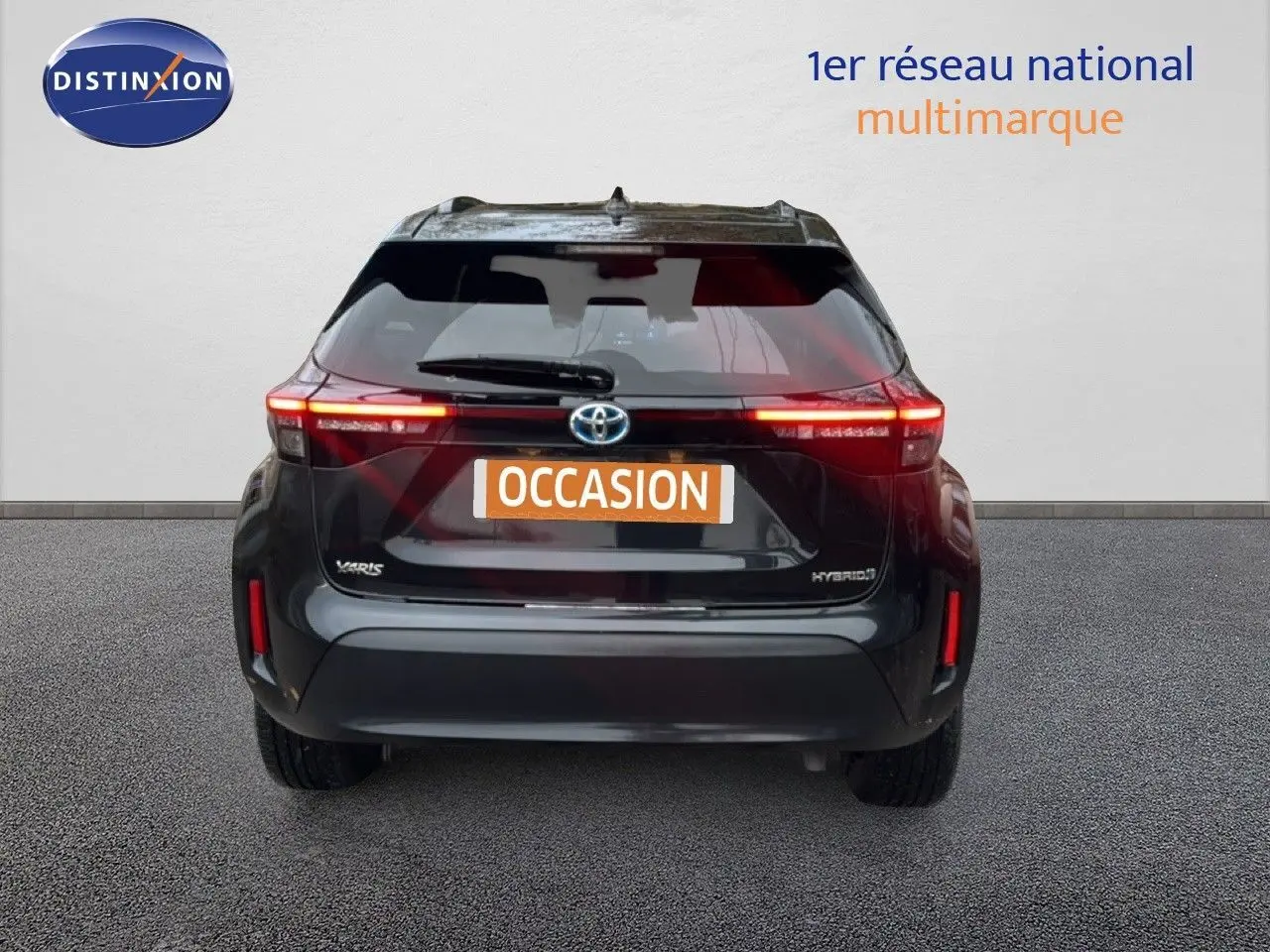 Vue arrière d'une Toyota Yaris Cross 116h Design noire de 2023 avec feux allumés et plaque occasion.