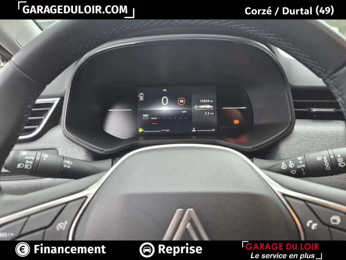 Vue rapprochée du tableau de bord numérique et du volant en cuir synthétique de la Renault Clio gris clair Evolution TCe 90 -25.