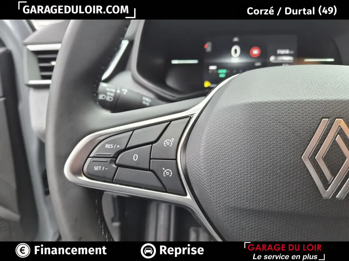 Gros plan sur le volant cuir synthétique gris avec commandes multifonctions à gauche d'une Renault Clio gris clair 2025.