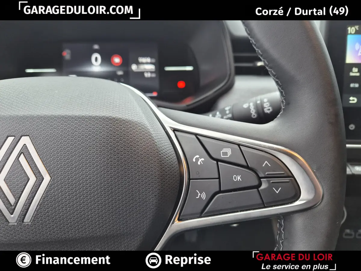 Gros plan sur le volant cuir synthétique gris foncé de la Renault Clio 2025 avec commandes multifonctions visibles.