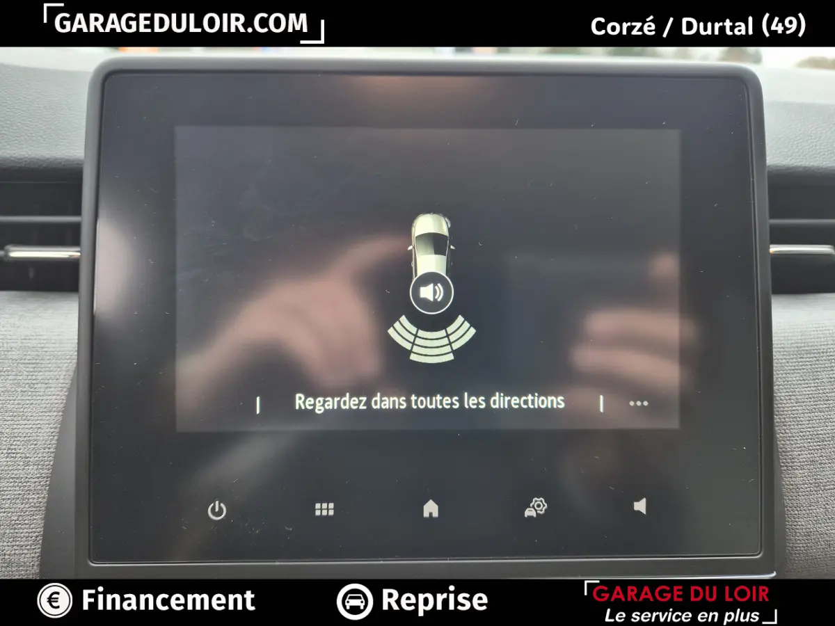 Écran tactile central de la Renault Clio gris clair affichant une alerte de surveillance des angles morts.