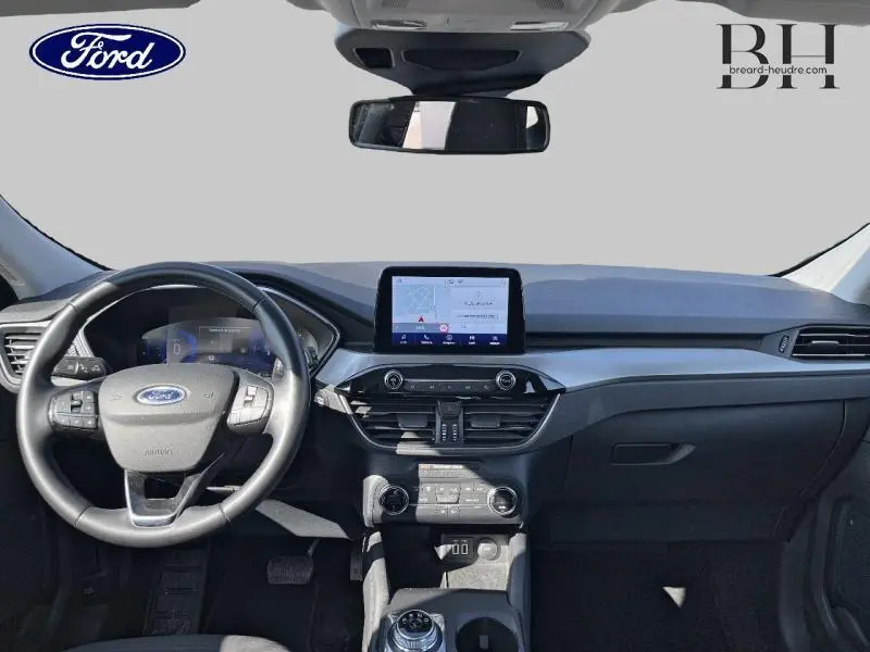 Vue frontale de l'habitacle du Ford Kuga 2022 avec tableau de bord noir et écran tactile central.