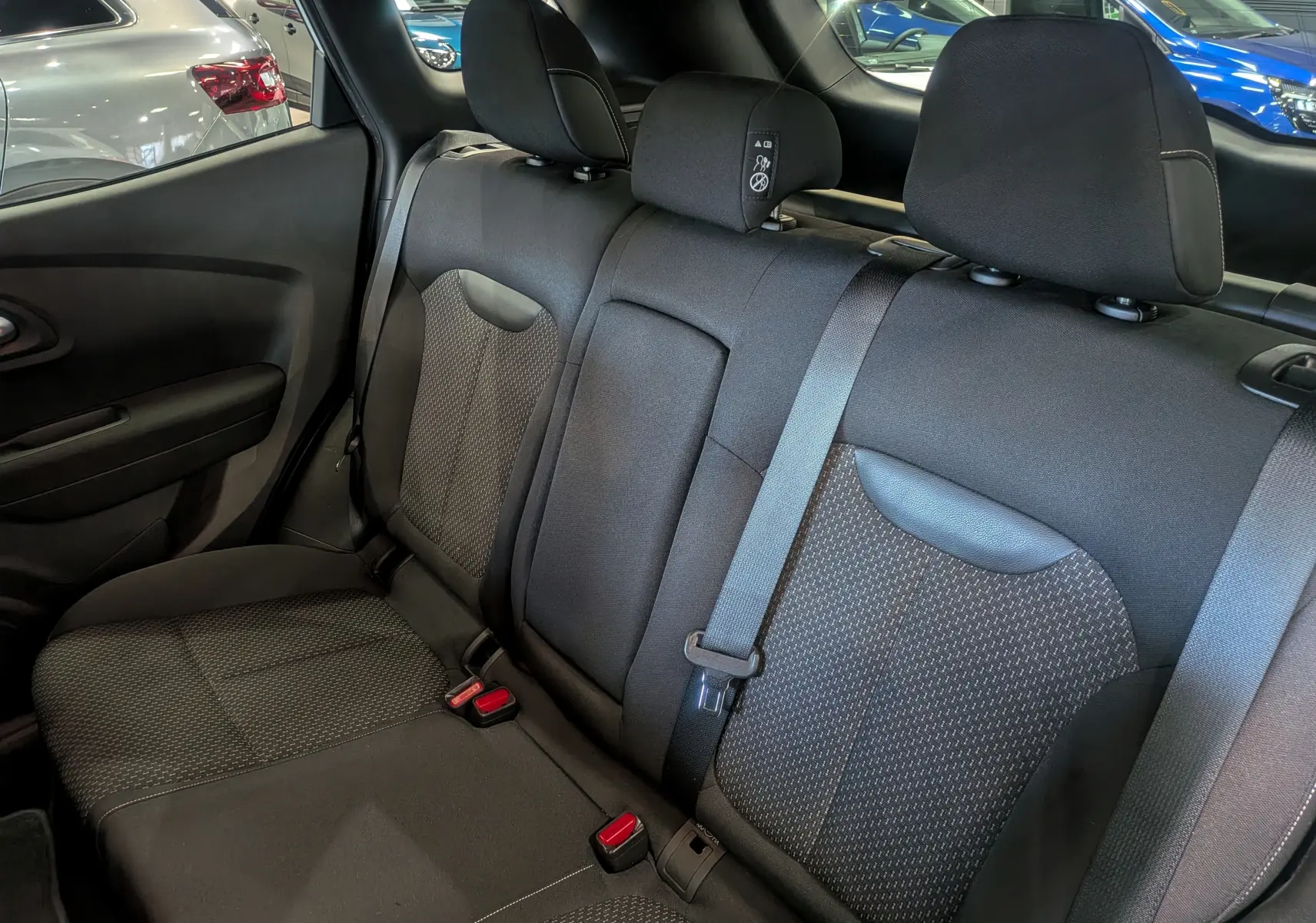 Vue intérieure sur la banquette arrière en tissu gris foncé du Renault Kadjar 2021, avec ceintures de sécurité visibles.