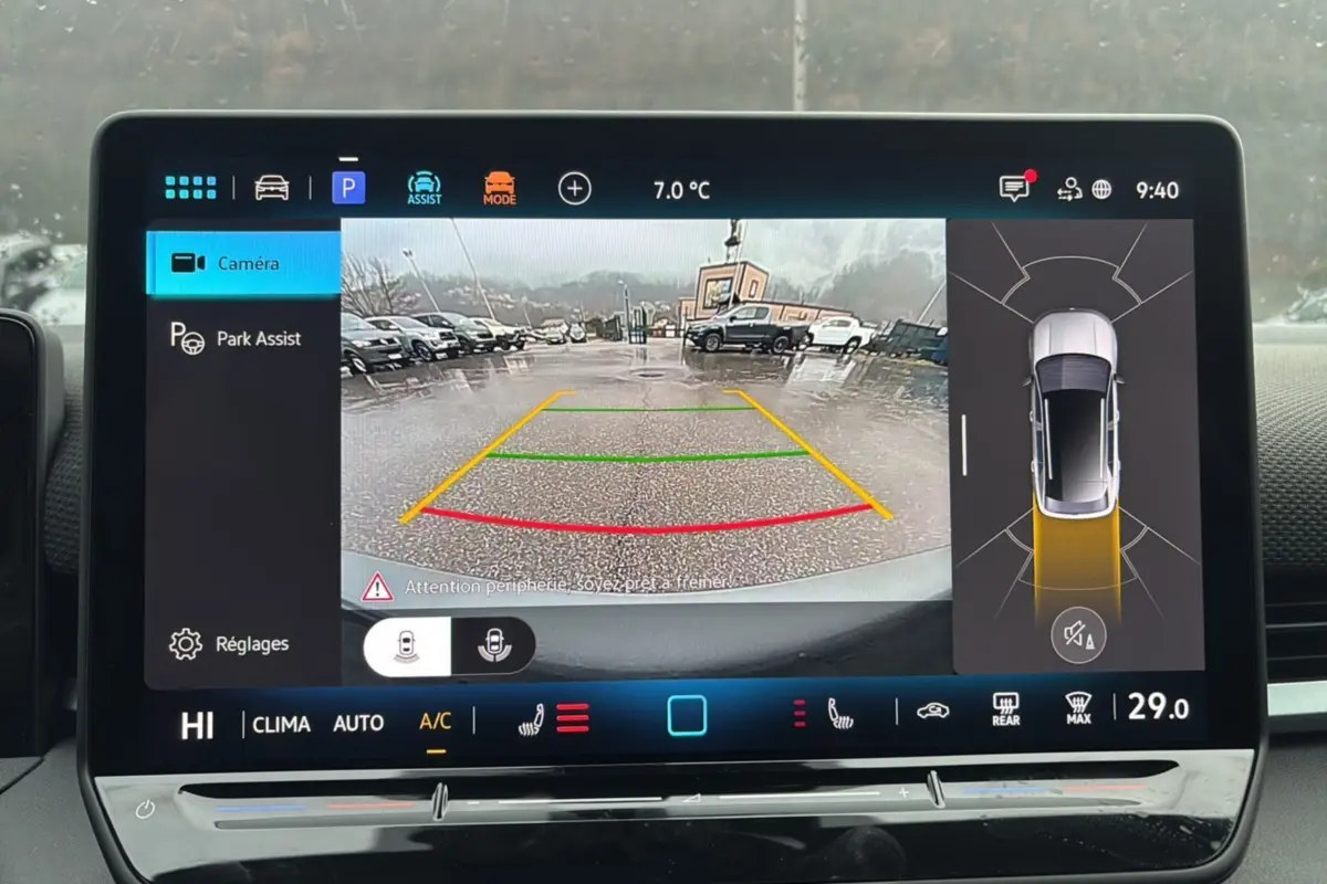 Écran multimédia affichant la caméra de recul et l'assistance au stationnement d'un Volkswagen T-Roc gris loup.