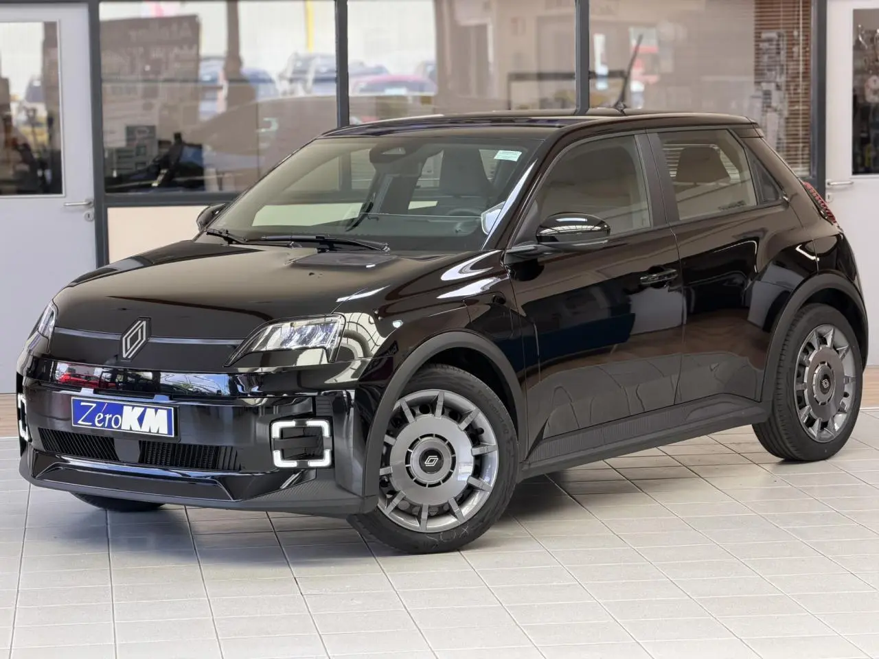 Renault R5 E-Tech électrique noir étoilé vue 3/4 avant droit avec signature lumineuse full LED et jantes acier 18 pouces.