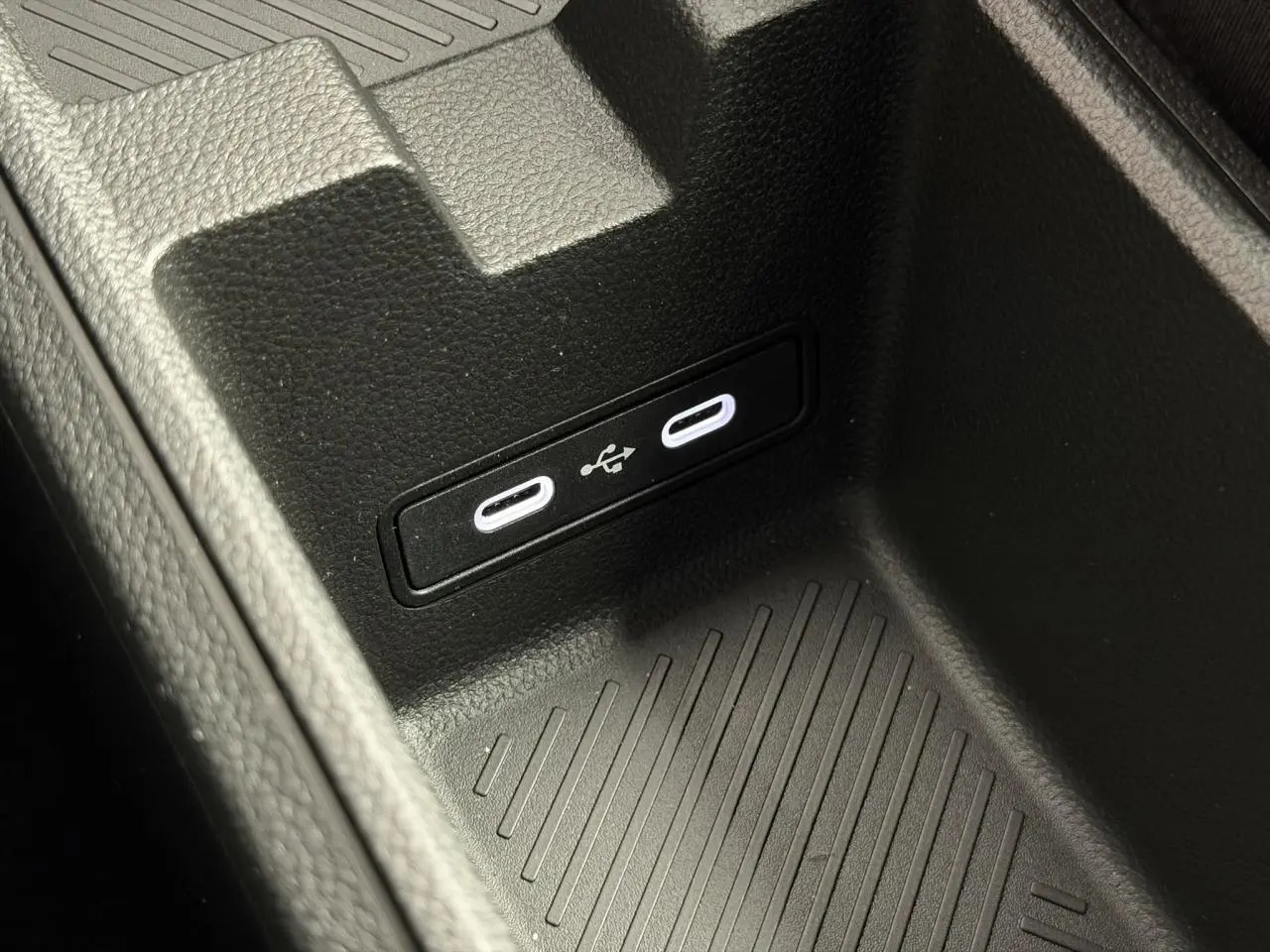 Gros plan sur la console centrale noire avec deux ports USB-C lumineux dans une Renault R5 E-Tech Electrique 2026.