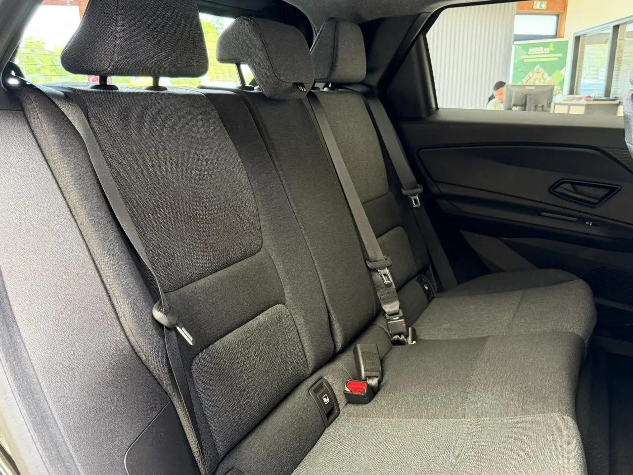 Vue latérale intérieure des sièges arrière gris foncé de la Renault R5 E-Tech Electrique 2026 avec ceinture de sécurité visible.