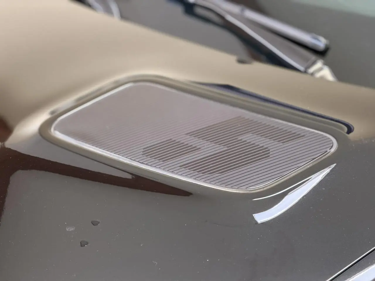 Gros plan sur le capot noir étoilé de la Renault R5 E-Tech avec logo "5" stylisé en relief.