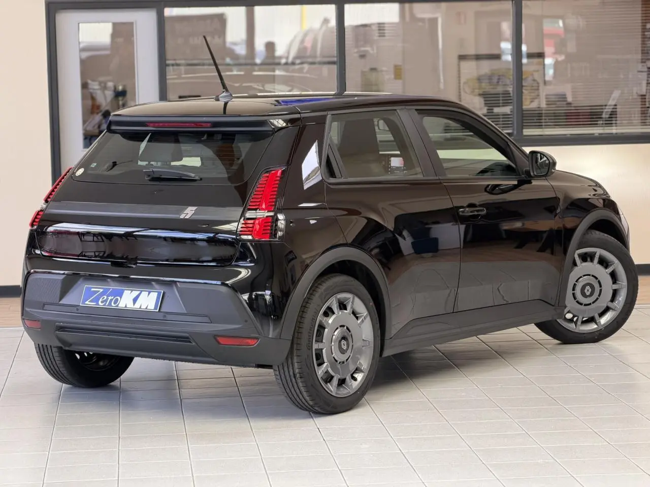 Vue 3/4 arrière droite d'une Renault R5 E-Tech électrique noire étoile avec feux arrière full LED et jantes acier 18 pouces.