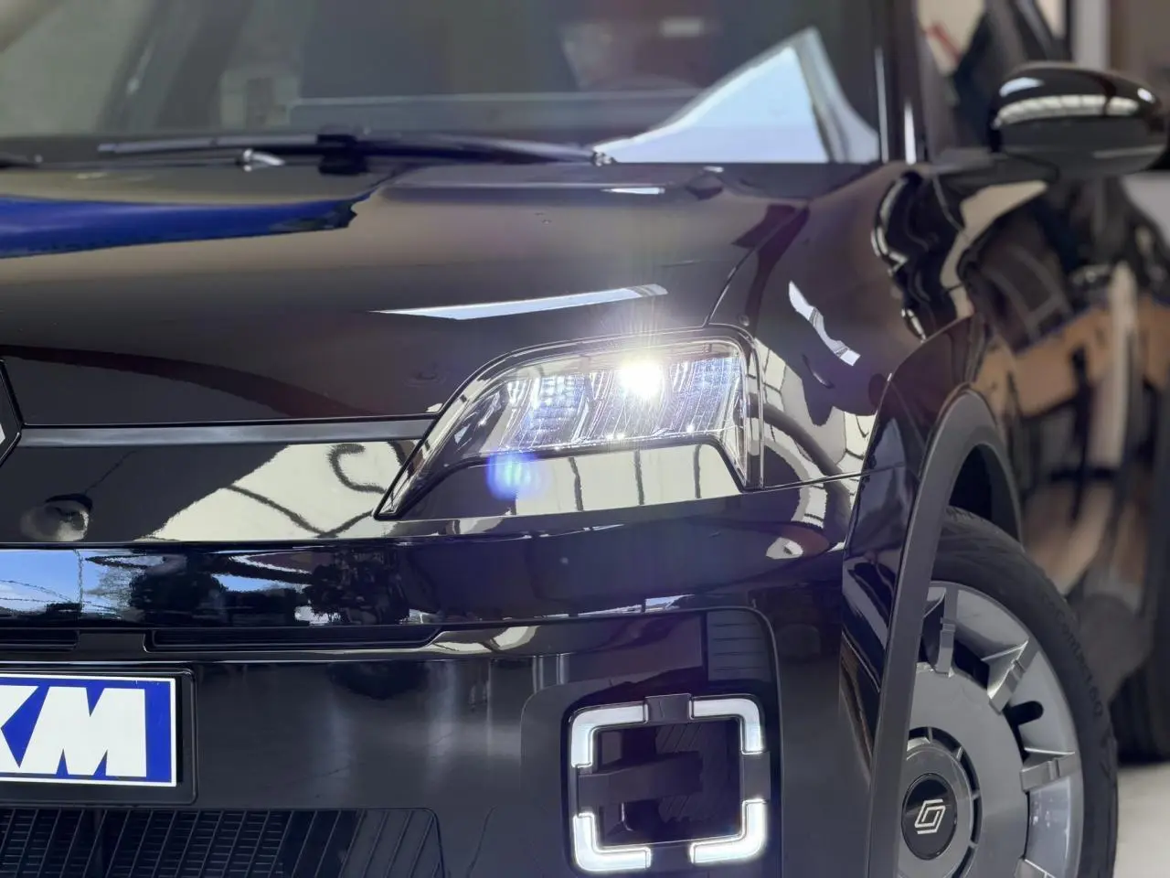 Vue 3/4 avant droit de la Renault R5 E-Tech électrique 2026 en Noir Étoilé avec phares et feux LED allumés.