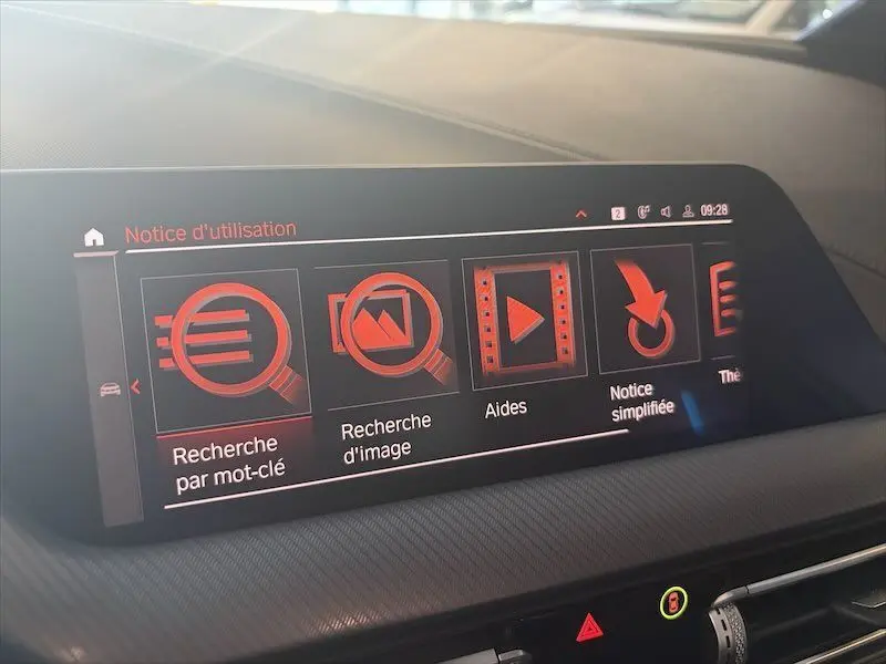 Écran tactile intérieur de la BMW Série 1 2020 affichant le menu d’aide avec icônes rouges sur fond noir.
