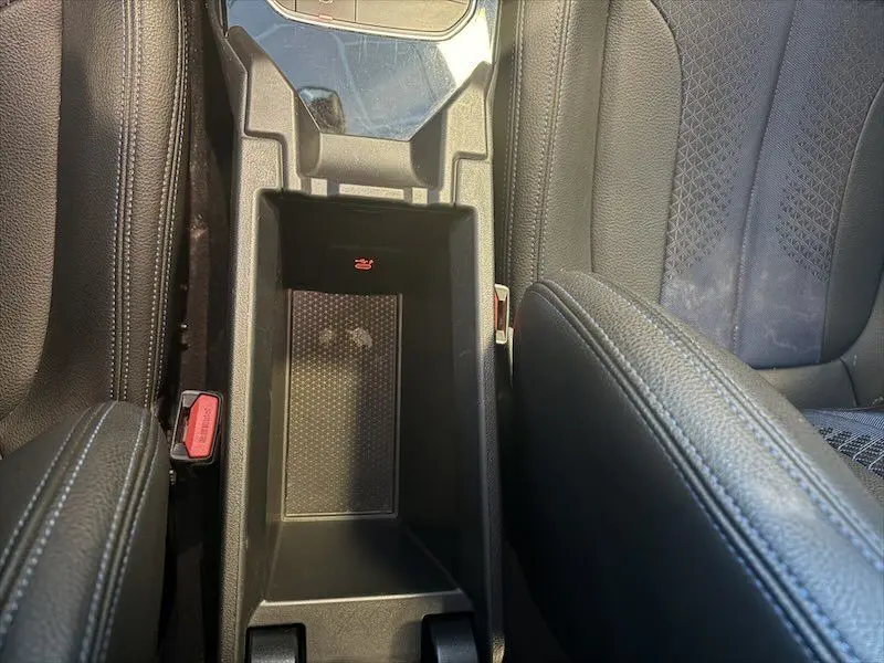 Vue plongeante sur la console centrale noire et les sièges en tissu noir de la BMW Série 1 118d M Sport 2020.