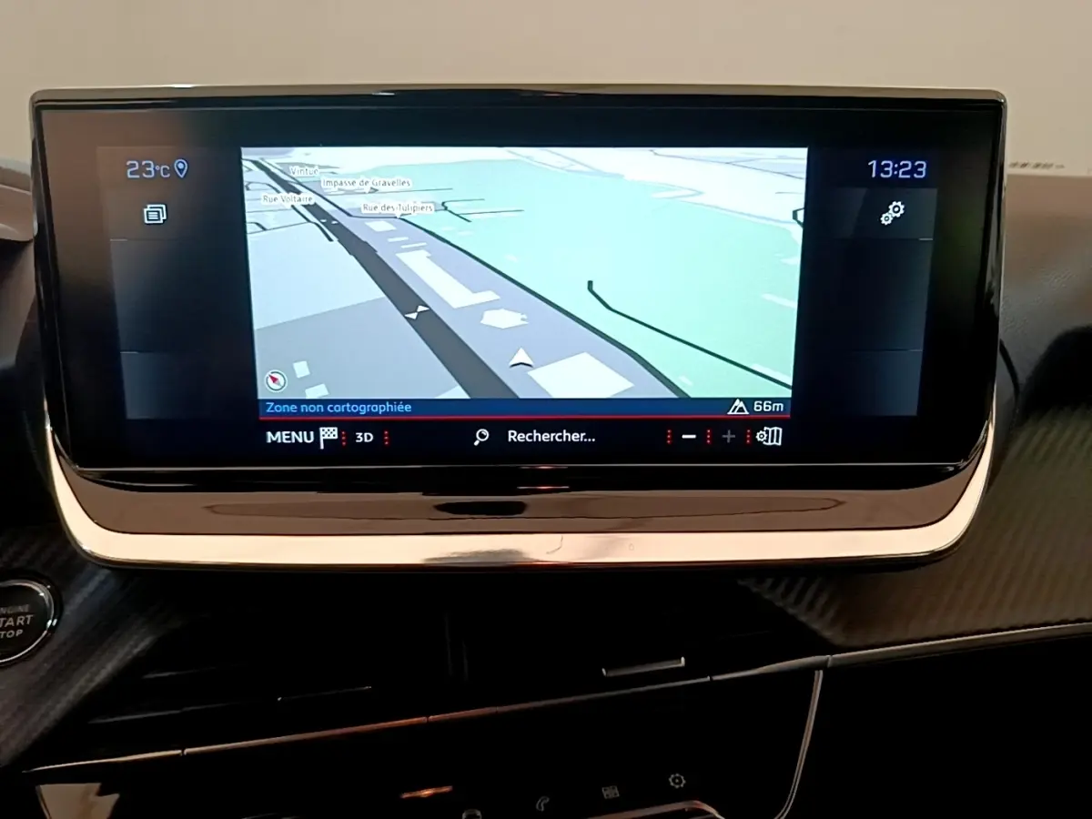 Écran tactile de navigation 10 pouces du tableau de bord de la Peugeot 208 blanche, vue intérieure frontale.