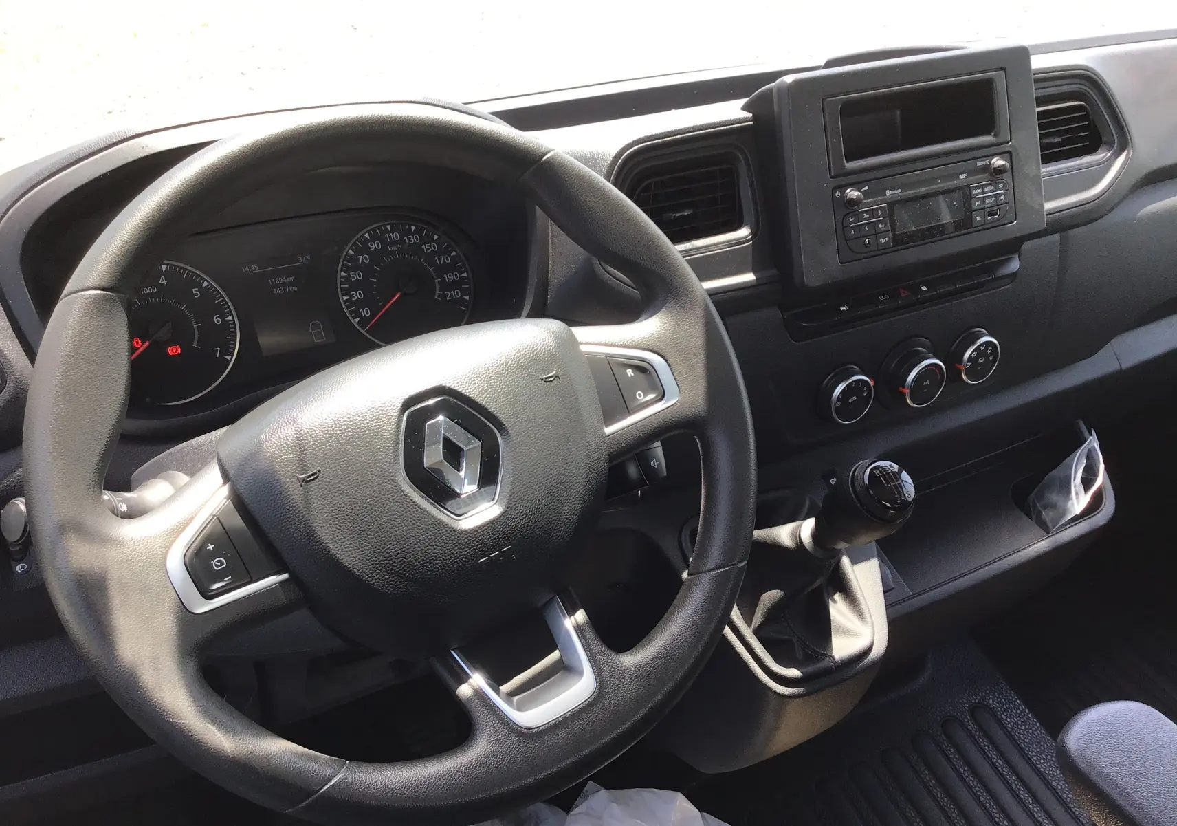 Vue intérieure du tableau de bord et volant noir du Renault Master Châssis Cabine 2024 avec levier de vitesses manuel.
