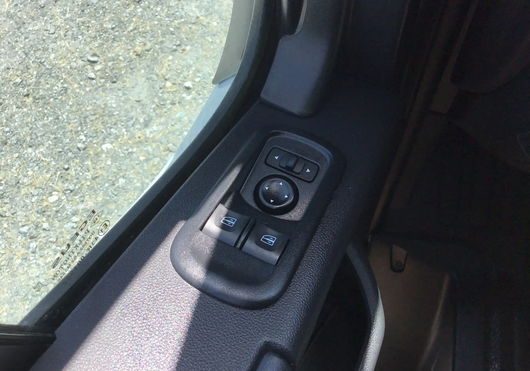 Gros plan sur les commandes électriques des vitres et des rétroviseurs côté gauche du Renault Master Châssis Cabine blanc.