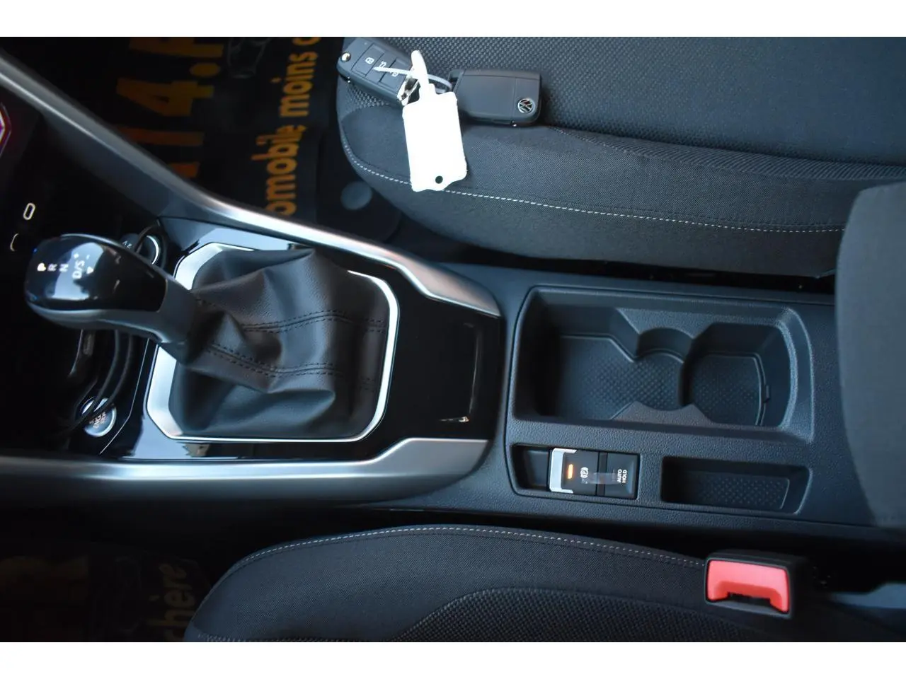 Vue intérieure centrée sur la console centrale et levier de vitesse du Volkswagen T-Roc 2025 avec sellerie noire.